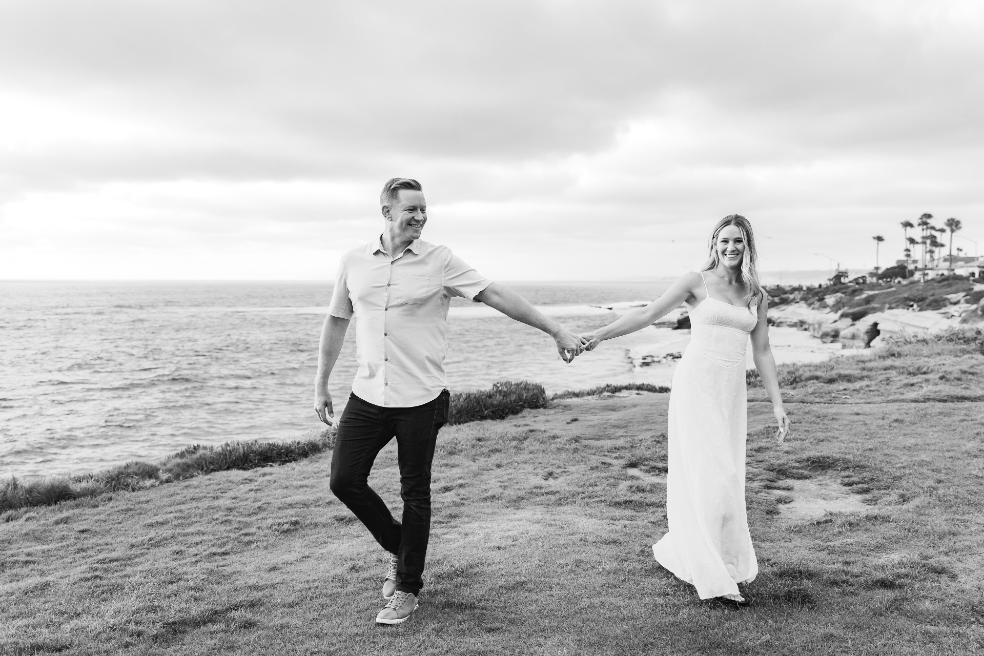 Carley and Connor, founders of Myzer, holding hands along the coast.